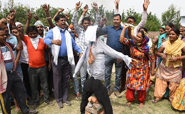 Migrant labourers from Bihar and Uttar Pradesh shout slogans and burn an effigy of Home Ministry Amit Shah in Amritsar.