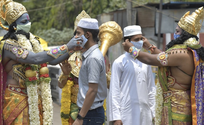 Men dressed as deities distribute face masks to the public on the occasion of Ram Navami, in Bangalore.