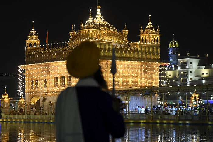 Sikh devotees pay respect at the illuminated Golden Temple on the eve of 400th birth anniversary of Guru Teg Bahadur in Amritsar.