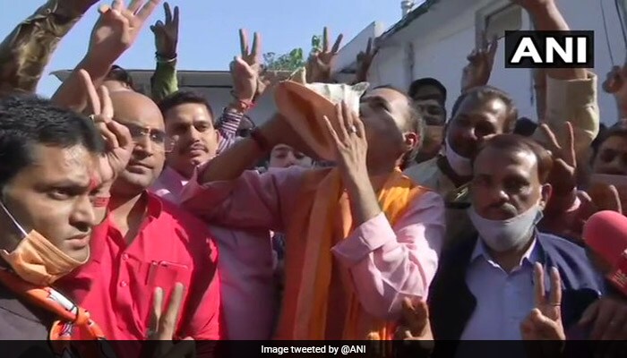 A BJP supporter blows a conch shell, others cheer at party office as NDA is leading as per the latest Election Commission trends