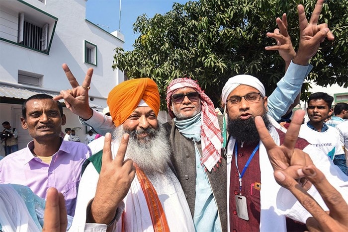 NDA supporters flash victory signs as they celebrate the alliance's lead during counting of votes in Patna