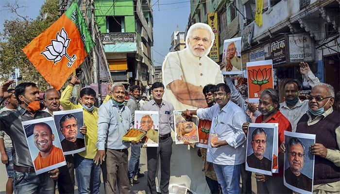 BJP workers celebrate the NDA's lead in Bihar Assembly elections and party's lead in UP Assembly bypolls in Varanasi