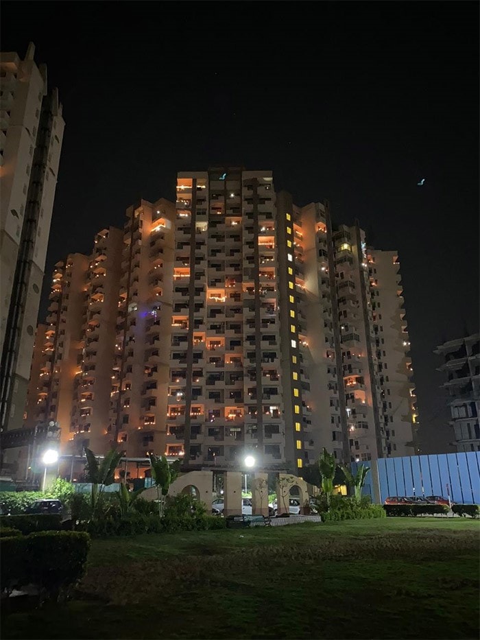 As the clock struck 9, lights went out in most houses and people gathered in balconies and at doors, flashing mobile lights while many lit candles and <i>diyas</i>