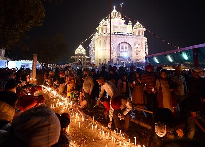 Devotees light candles at Gurdwara Rakab Ganj Sahib on the occasion of the 550th birth anniversary of the first Sikh Guru Nanak Dev ji, in New Delhi.