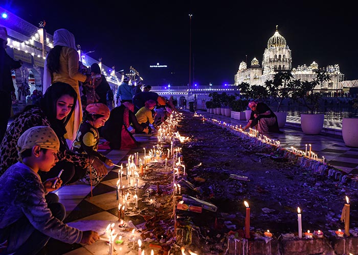 Devotees light candles at Gurudwara Bangla Sahib on the eve of the 550th birth anniversary of Guru Nanak Dev ji, in New Delhi, on Monday.