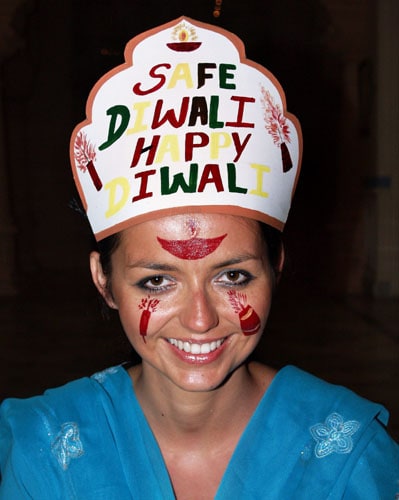 <b>Lighting up the world</b>: A foreign tourist paints herself to indulge in the moods of Diwali in Bikaner. <I>( PTI )</I>