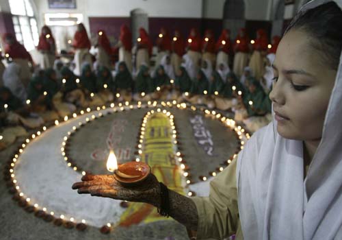 <b>The victory lamp</b>: Muslim students hold candles as they jointly celebrate the success of India's moon mission and Diwali, at the Anjuman-e-Islam school in Ahmedabad. <I>(AP)</I>