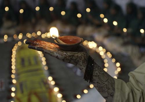 <b>Lamp of happiness</b>: A Muslim student holds an earthen lamp during an event to celebrate Diwali in Ahmadabad. <I>(AP)</I>