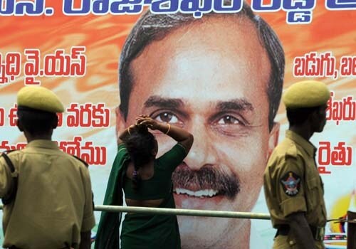 A supporter (C) breaks into tears in front of a poster of YSR Reddy at the Lal Bahadur Shastri Stadium in Hyderabad on September 4, 2009. (AFP Photo)