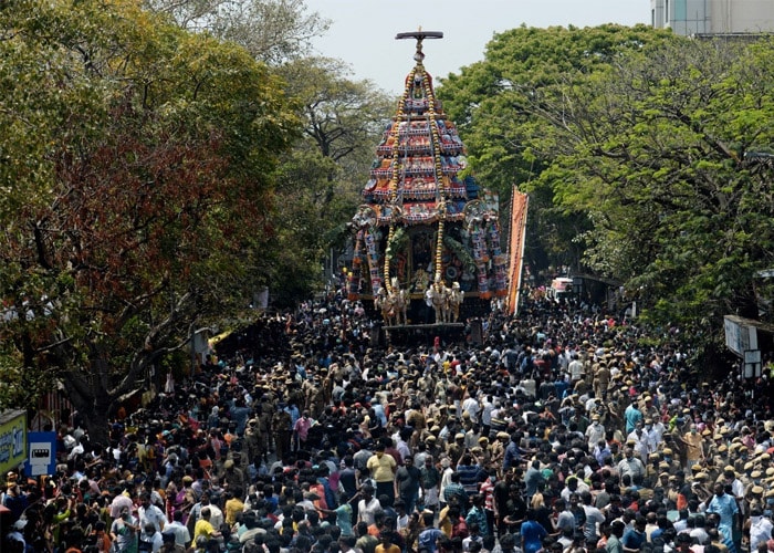 Devotees pull a large chariot decorated with flowers and idols of Hindu deity Kapaleeswar during an annual chariot festival in Chennai on March 25, 2021.