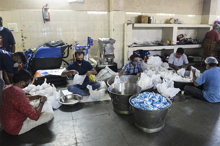 Volunteers pack food to be distributed among coronavirus patients in Hyderabad