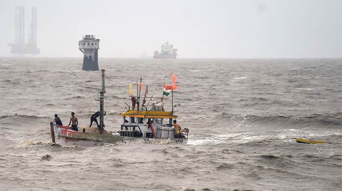 Fishermen try to recover their smaller boat which had drifted away due to rough sea owing to Cyclone Tauktae, in Mumbai