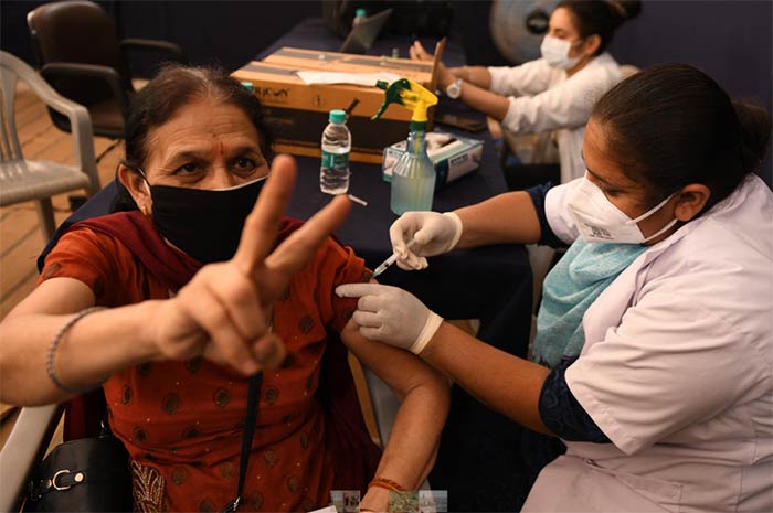 A woman recieves a dose of the Covishield coronavirus vaccine at Radha Soami Satsang Beas Centre in Amritsar
