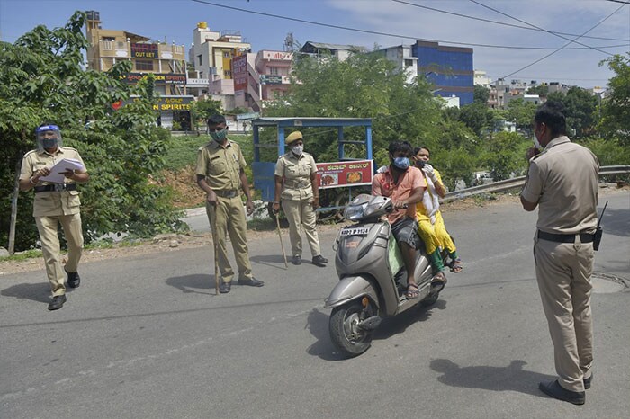 Policemen check identification documents of motorists during the coronavirus lockdown in Bengaluru