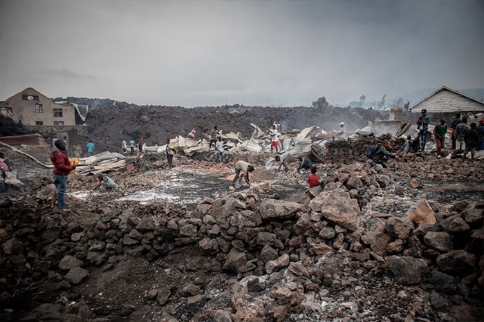 Residents sift through the cooling lava rocks from an eruption from Mount Nyiragongo in Democratic Republic of Congo. A river of boiling lava came to a halt on the outskirts of Goma on Sunday