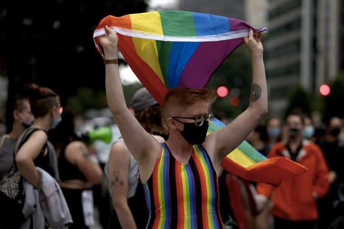 A person holds up a pride flag as they participate in the DC Dyke March on June 11, 2021 in Washington, DC. The march is the first in a series of Pride events planned to be held throughout the weekend in Washington DC.