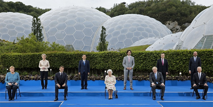 Britain's Queen Elizabeth II (C), poses for a familly photograph with, from left, Germany's Chancellor Angela Merkel, President of the European Commission Ursula von der Leyen, France's President Emmanuel Macron, Japan's Prime Minister Yoshihide Suga, Canada's Prime Minister Justin Trudeau, Britain's Prime Minister Boris Johnson, Italy's Prime minister Mario Draghi, President of the European Council Charles Michel and US President Joe Biden, during an evening reception at The Eden Project in south west England on June 11, 2021.