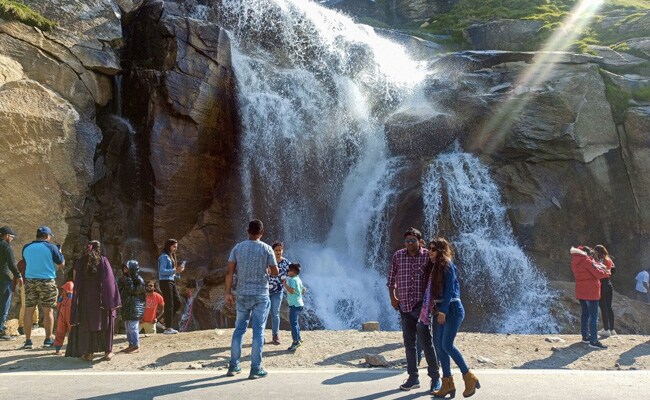 Tourists at a waterfall at Khoksar in Lahual Spiti district of Himachal Pradesh, on July 9, 2021. The Centre has warned against laxity in following Covid-appropriate behaviour, with reference to large crowds seen at popular holiday and tourist destinations.