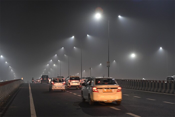 Commuters drive under heavy smog conditions along the Delhi-Meerut expressway near Akshardham temple