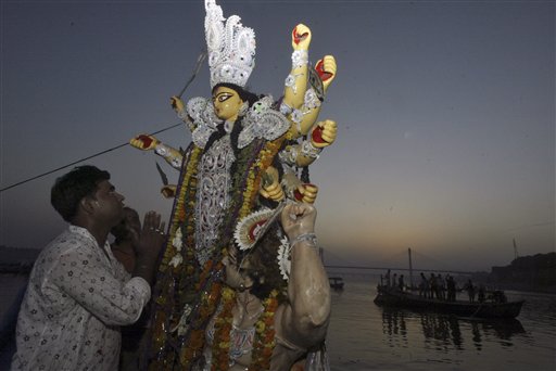 A Hindu devotee offers prayers before an idol of Goddess Durga, before its immersion in River Yamuna that culminates the Durga Puja festival, in Allahabad, India on Sunday The festival commemorates the slaying of a demon king by lion-riding, 10-armed goddess Durga, marking the triumph of good over evil.