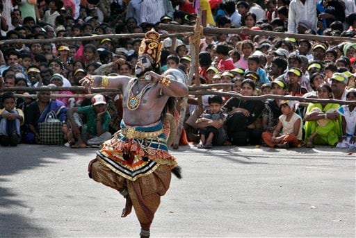 A man dressed as Hindu god Hanuman performs on a street as part of the last day Dussera celebrations in Mysore.