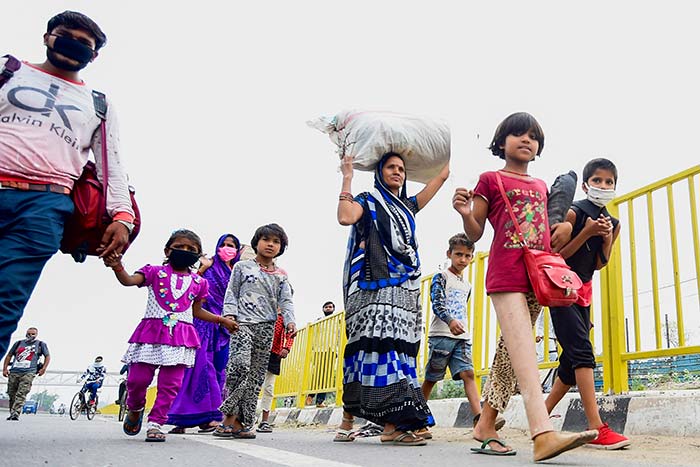 A girl (2nd R) with an artificial leg walks with her family of migrant workers towards their respective hometown states during a government-imposed nationwide lockdown as a preventive measure against the COVID-19 coronavirus.