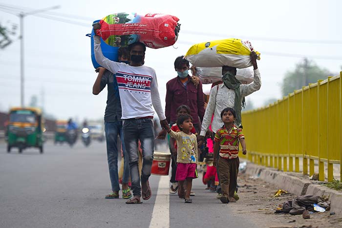 Migrant workers and their family members walk with their belongings towards their respective hometown states during a government-imposed nationwide lockdown as a preventive measure against the COVID-19 coronavirus.