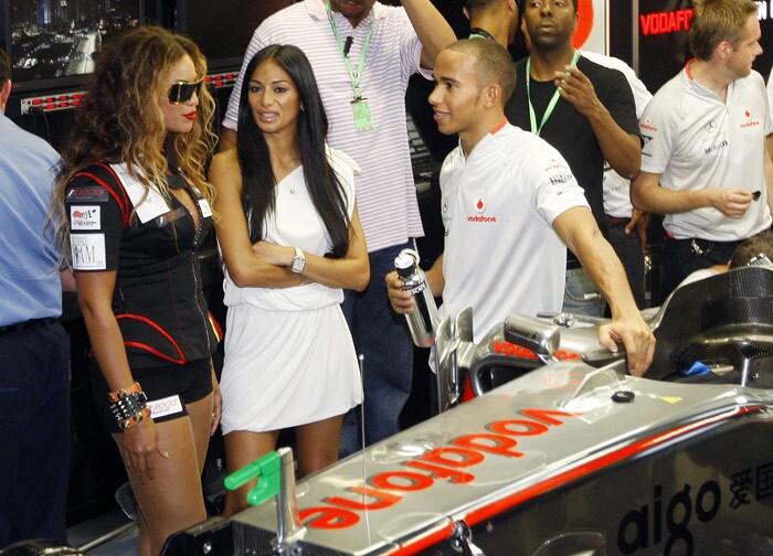 <font size="2">McLaren Formula One driver Lewis Hamilton right, talks with American music star Beyonce left, in his team garage after the third practice session on the Marina Bay City Circuit in Singapore, Saturday, Sept 26, 2009. Singapore will host the season's 14th Formula One Grand Prix on Sunday Sept. 27. (AP Photo/Dita Alangkara)</font>