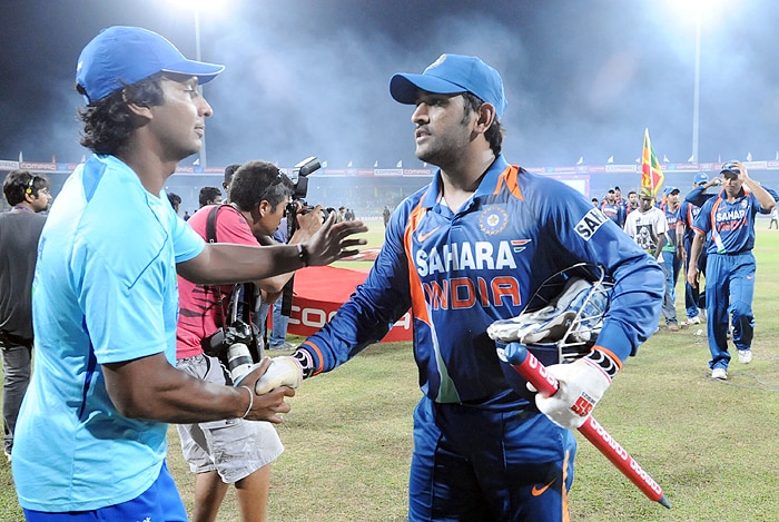 Sri Lankan captain Kumar Sangakkara is congratulated by Indian captain MS Dhoni after victory in the Tri-Nation Championship trophy final ODI match at the R. Premadasa Stadium in Colombo on Monday. (AFP Photo)