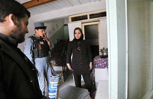 In this picture, Shekiba is on a house search with police in Kabul. She hasn't told the police academy about her acting. (NYT PHOTO)