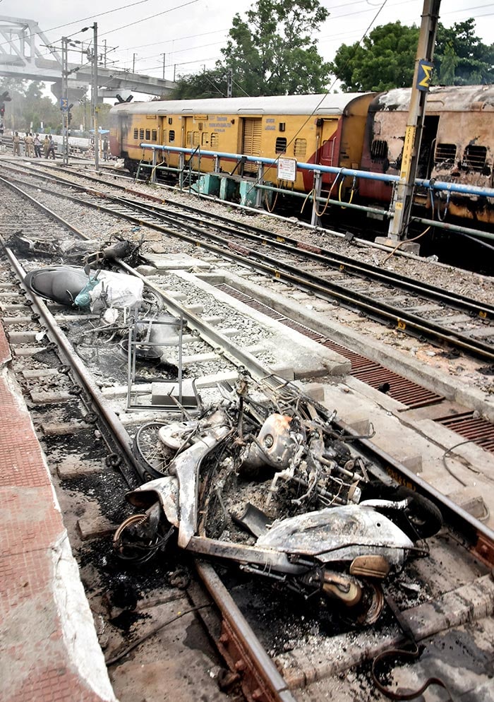 Vehicles set on fire on a railway track during a protest against the 'Agnipath' scheme, at Secunderabad railway station in Hyderabad.