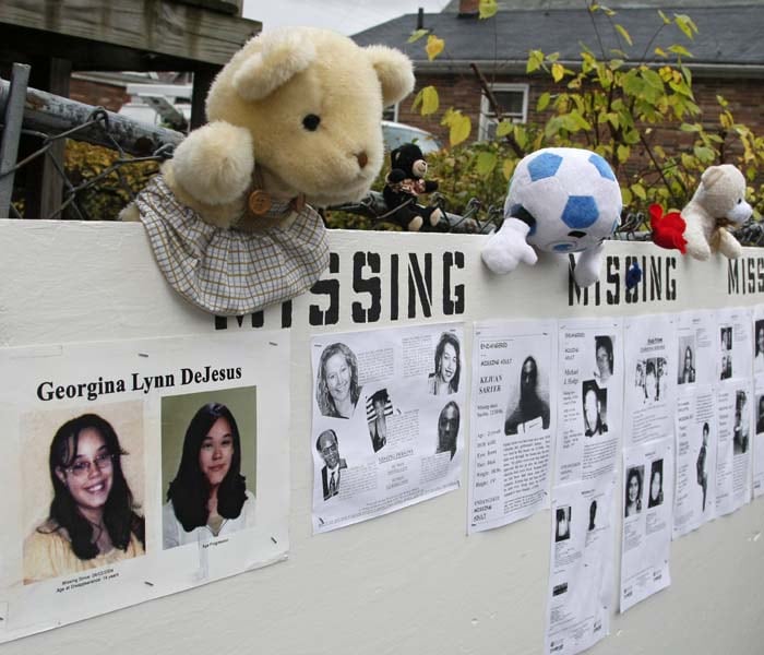 The pictures of missing victims have been put on a board with flyers clinged to a fence in Anthony Sowell's home. (AP Photo)