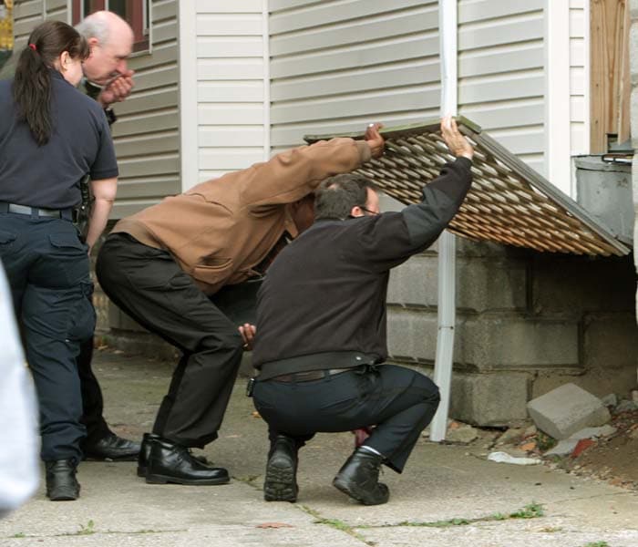 Cleveland police searched the porch at the home of Anthony Sowell, where bodies were discovered. The Police says officers who went to the home of the alleged rapist, found two decomposing bodies upstairs and what appeared to be a freshly dug grave in the basement. (AP Photo)