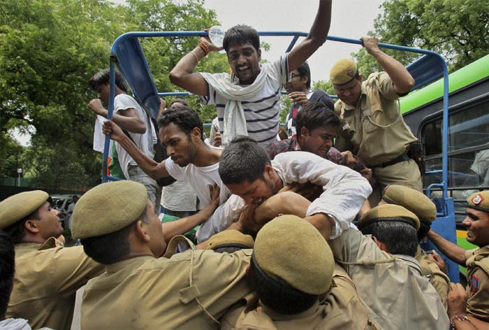 Delhi Police officials arresting supporters protesting outside Pranab Mukherjee's residence.