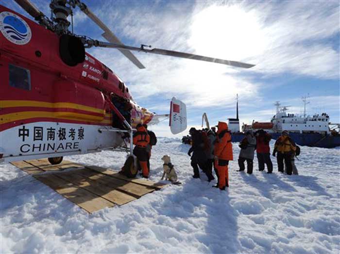 In this photo provided China's official Xinhua News Agency, passengers from the trapped Russian vessel MV Akademik Shokalskiy, seen at right, prepare to board the Chinese helicopter Xueying 12 in the Antarctic on January 2, 2014.