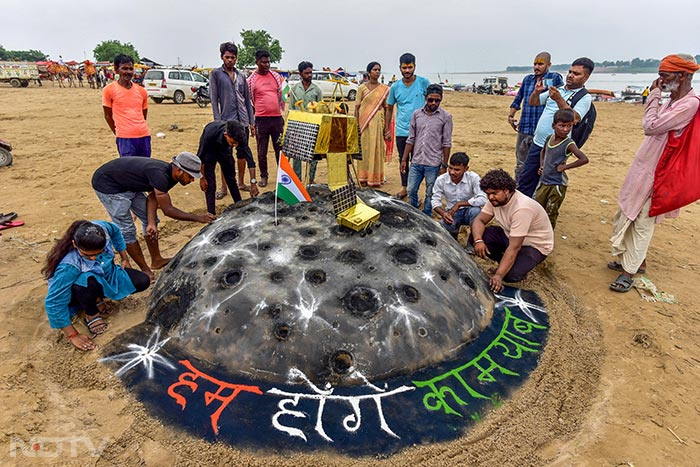 इलाहाबाद केंद्रीय विश्वविद्यालय के छात्रों ने प्रयागराज में संगम पर चंद्रयान-3 की सफल लैंडिंग की कामना करते हुए रेत पर अकृति बनाई. फोटो: पीटीआई