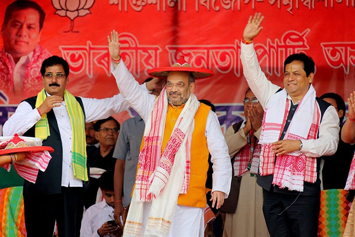 BJP president Amit Shah and BJP's chief ministerial candidate Sarbananda Sonowal wave the crowd at an election rally in Naoboicha in Assam.