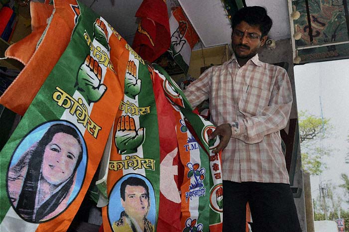 A shopkeeper in Murshidabad arranges flags bearing the symbols of various political parties ahead of the West Bengal assembly polls. (PTI)