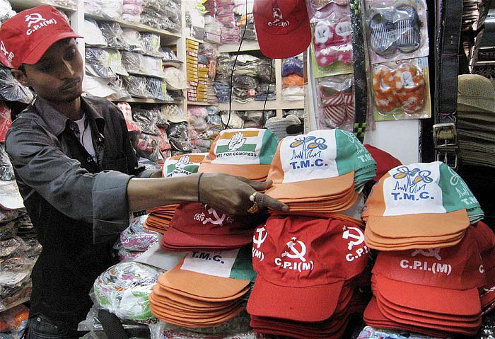 A shopkeeper in Siliguri arranges caps designed with the symbols for various political parties ahead of the West Bengal assembly polls. (PTI)