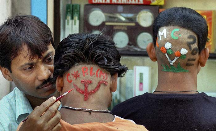 Supporters of the CPI(M) and the Trinamool Congress get special haircuts in the Howrah district to participate in the West Bengal assembly election campaigns. (PTI)