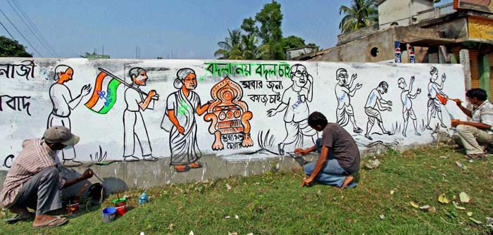 Trinamool Congress workers paint a wall graffiti on the outskirts of Bolpur in the Birbhum district of West Bengal ahead of the assembly elections in the state. (PTI)