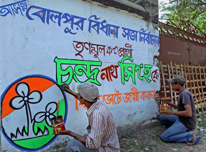 Trinamool Congress workers paint a wall graffiti in the Birbhum district ahead of the West Bengal assembly elections. (PTI)