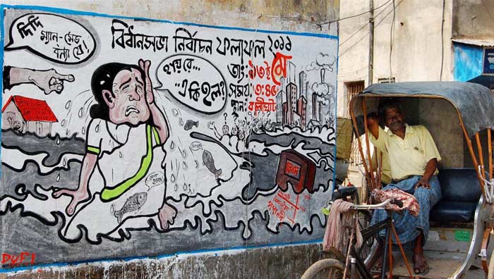 A rickshaw is seen in the backdrop of a CPI(M) wall graffiti in Nadia ahead of the West Bengal assembly elections. (PTI)