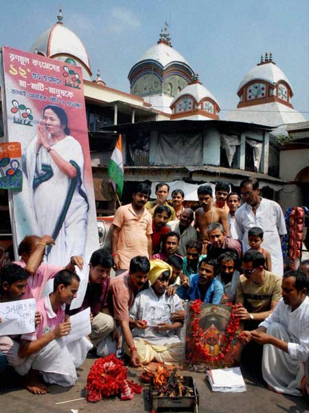 Trinamool Congress and Congress supporters take part in a ritual at the Kalighat temple in Kolkata for both the continuation of the parties' alliance and success in the upcoming West Bengal assembly elections. (PTI)