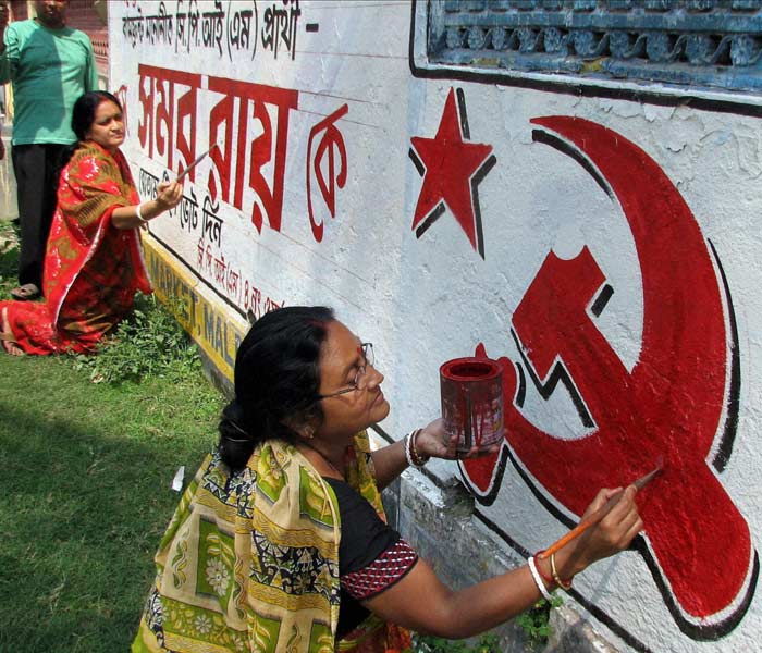 Women activists of CPI(M) prepare a wall graffiti in the Malda district of West Bengal for the upcoming assembly elections in the state.(PTI)