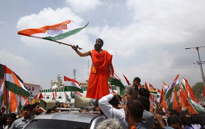 Yoga guru Baba Ramdev waves the national flag from atop a jeep as he along with his supporters march to Parliament to intensify an anti-corruption protest and press for a change of government in New Delhi.