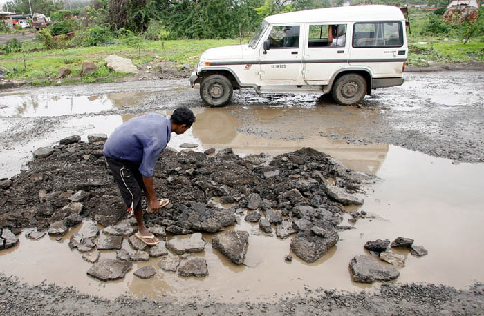 <p>A labourer repairs a stretch of damaged road in Mumbai, 09 July 2007. The city civic authorities had gone on an overdrive to repair potholes and damaged roads which the high court had earlier ordered the city civic body to complete by 31 May 07. (AFP Photo)</p>
<div><font face="Arial" color="#000000" size="2"></font></div>
<a class="fn fl fa fs12" target="_Blank" href="http://www.ndtv.com/convergence/ndtv/new/india.aspx">Seen worse roads? Share pictures with us.</a>