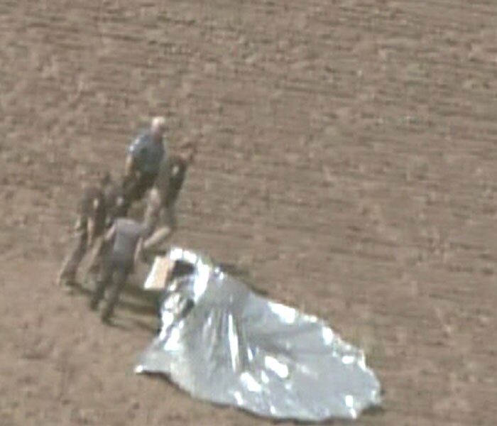 In this framegrab courtesy of Fox News Colorado first responders gather around a homemade balloon after it landed in a field on October 15, 2009. The helium balloon broke from its tethers at a Fort Collins, Colorado, home sparking a full-scale rescue operation for six-year-old Falcon Heene believed to be aboard the saucer-shaped craft. Multiple media reports put the craft hurtling through the sky thousands of feet in the air moving at up to 25 miles (40 kilometers) an hour as a captivated nation watched fearing for the fate of its presumed passenger, young. The boy was not found in the balloon, forcing rescuers to continue the search. (AFP Photo)