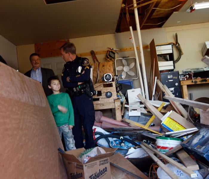 Falcon Heene (C) stands in the garage where he earlier climbed up PVC pipes to hide in the attic. (AFP Photo)