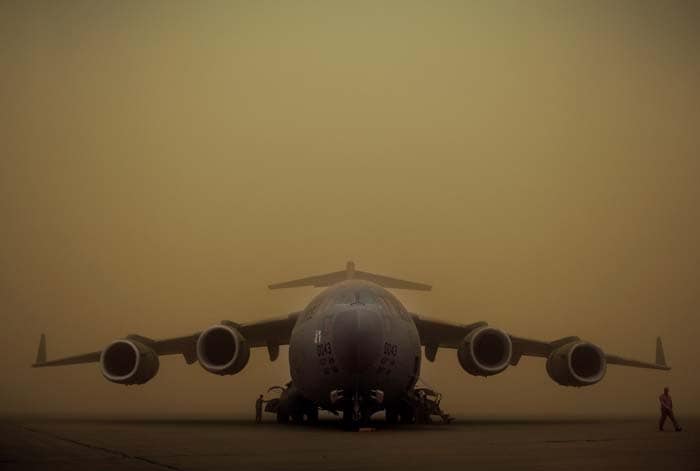 Against a hazy background, the Boeing C-17 stands on the tarmac.